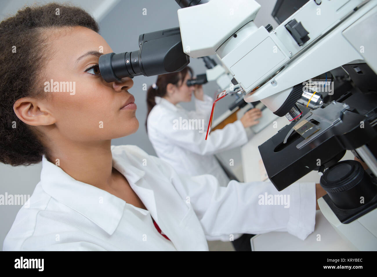 schöne Wissenschaftler Blick durch ein Mikroskop Stockfoto