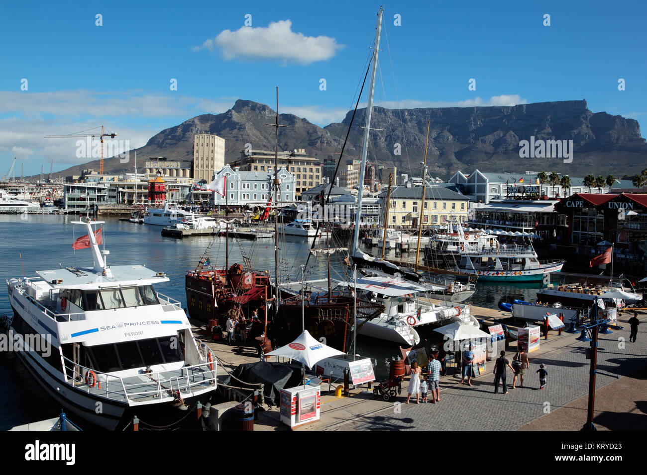Kapstadt, Südafrika - 20. FEBRUAR 2012: Victoria und Alfred Waterfront, Hafen mit Booten, Geschäften, Restaurants und den berühmten Tafelberg. Stockfoto