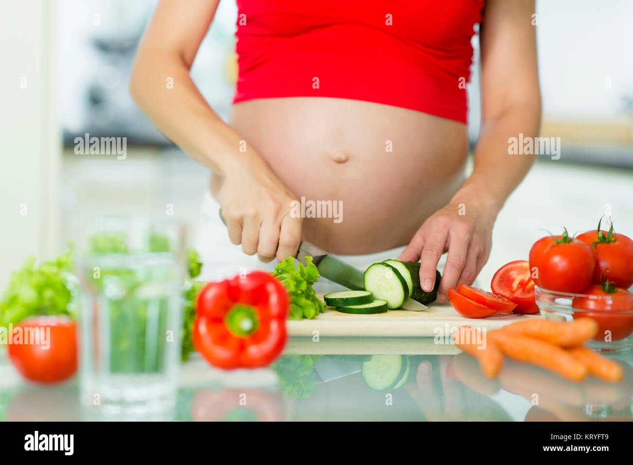 Schwangere Frau beim Kochen mit Gemüse - schwangere Frau Kochen Gemüse Stockfoto