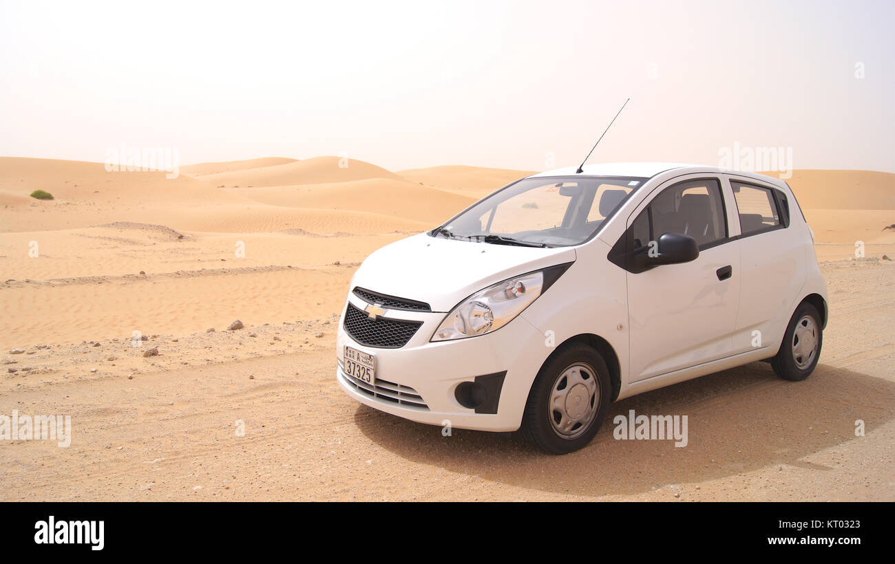 ABU DHABI, VEREINIGTE ARABISCHE EMIRATE - April 3rd, 2014: Liwa Wüste in Abu Dhabi Western Region Al Gharbia mit einem kleinen weißen Auto vor Stockfoto