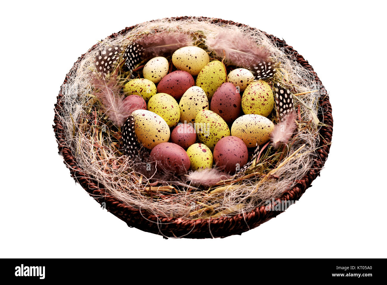 Dekorative Ostereier im Korb mit Heu und Perlhühner Federn Stockfoto