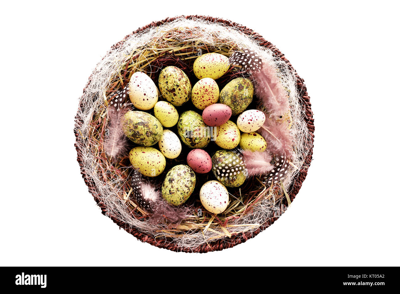 Dekorative Ostereier im Korb mit Heu und Perlhühner Federn Stockfoto