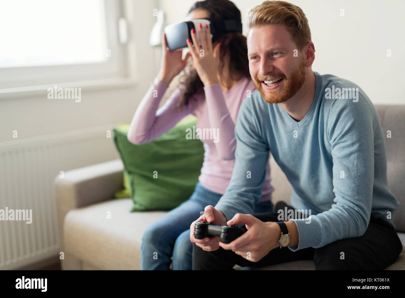 Glückliches junges Paar Spielen von Videospielen mit Virtual reality Headsets Stockfoto