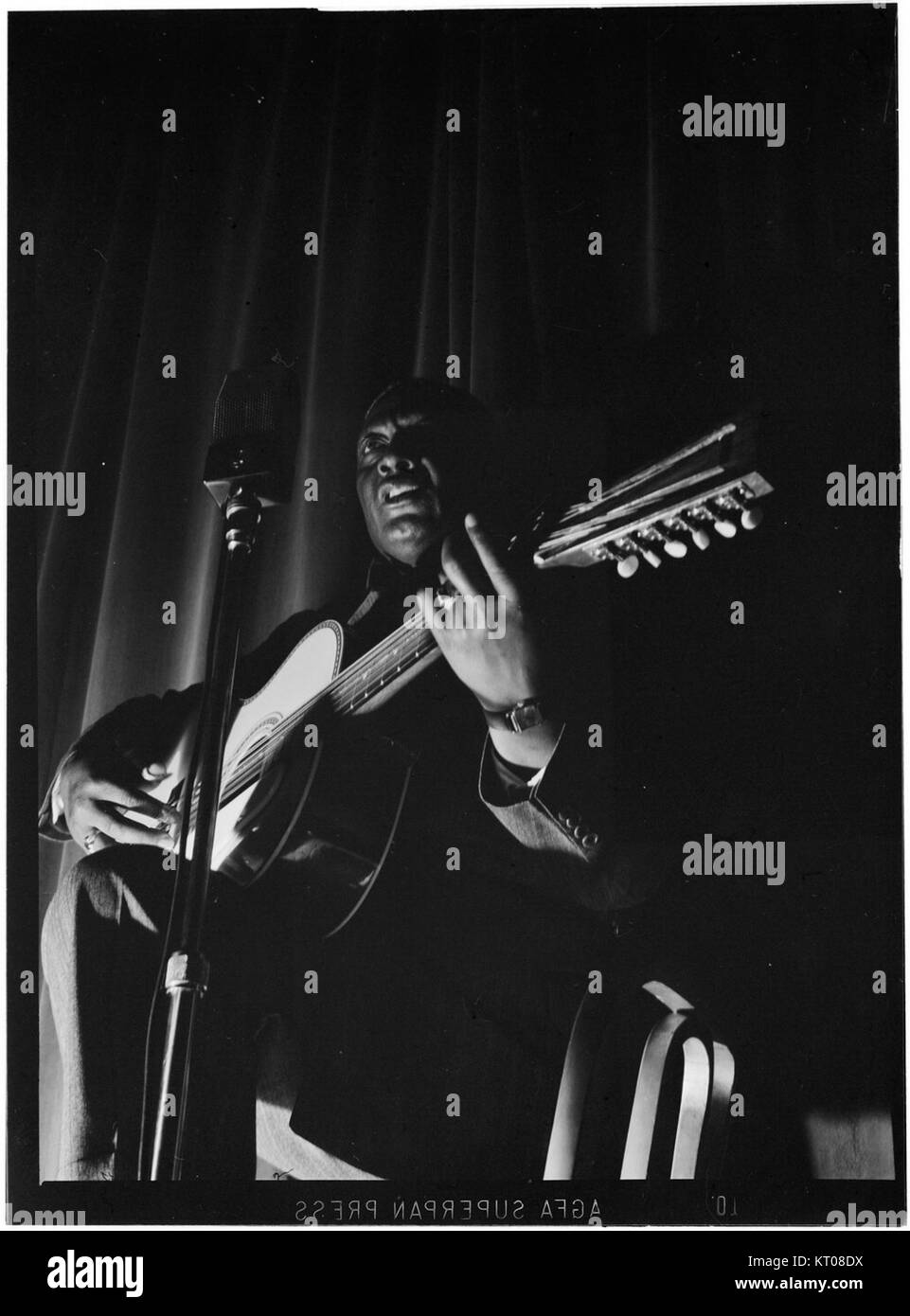 Dieses Porträt von Leadbelly, das zwischen 1938 und 1948 im National Press Club in Washington, D.C. aufgenommen wurde, fängt den berühmten amerikanischen Folk- und Bluesmusiker ein. Leadbelly, bekannt für seine kraftvolle Gesangs- und Songkomposition, hatte einen bedeutenden Einfluss auf die amerikanische Musikgeschichte. Stockfoto