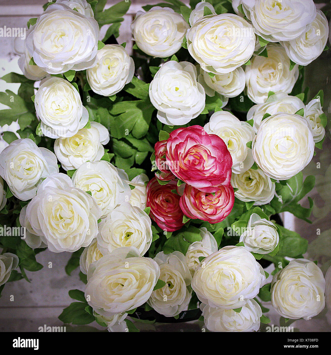 Eine Sammlung künstlicher Rosen, entworfen, um echte Blumen nachzuahmen. Diese dekorativen Gegenstände werden häufig in Arrangements, Wohnaccessoires und besonderen Anlässen verwendet und bieten eine langlebige Alternative zu frischen Rosen. Stockfoto