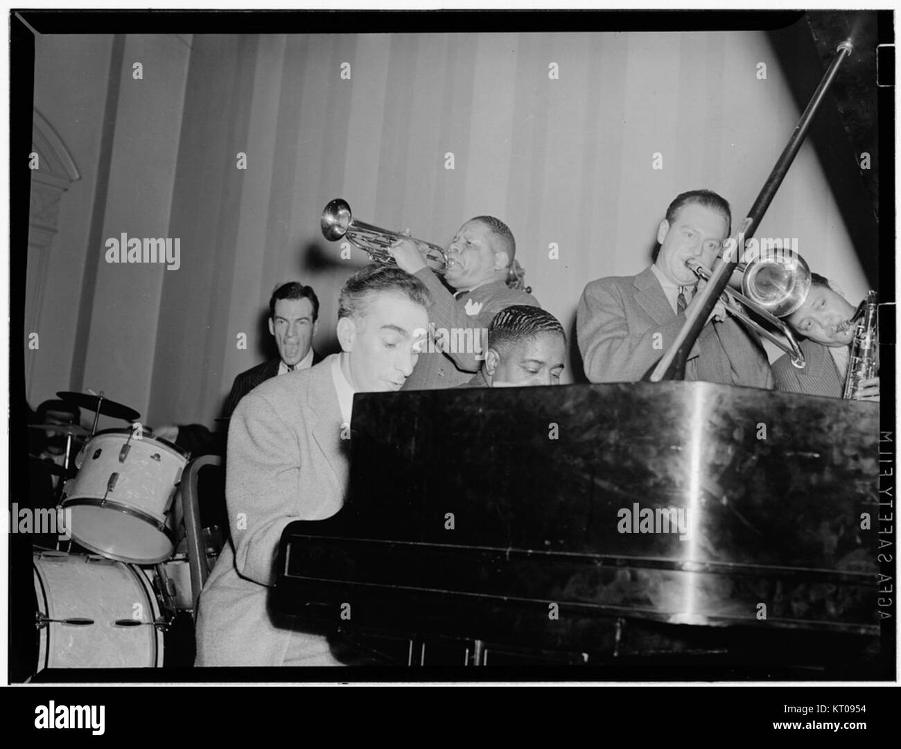 Dieses Foto zeigt prominente Jazzmusiker Art Hodes, Henry Allen, Pete Johnson, Lou McGarity und Lester Young, aufgenommen im National Press Club in Washington, D.C. um 1940. Das Bild fängt die kulturelle Bedeutung des Jazz während dieser Zeit ein und dient als wichtiges historisches Album der Musikszene in den Vereinigten Staaten. Stockfoto