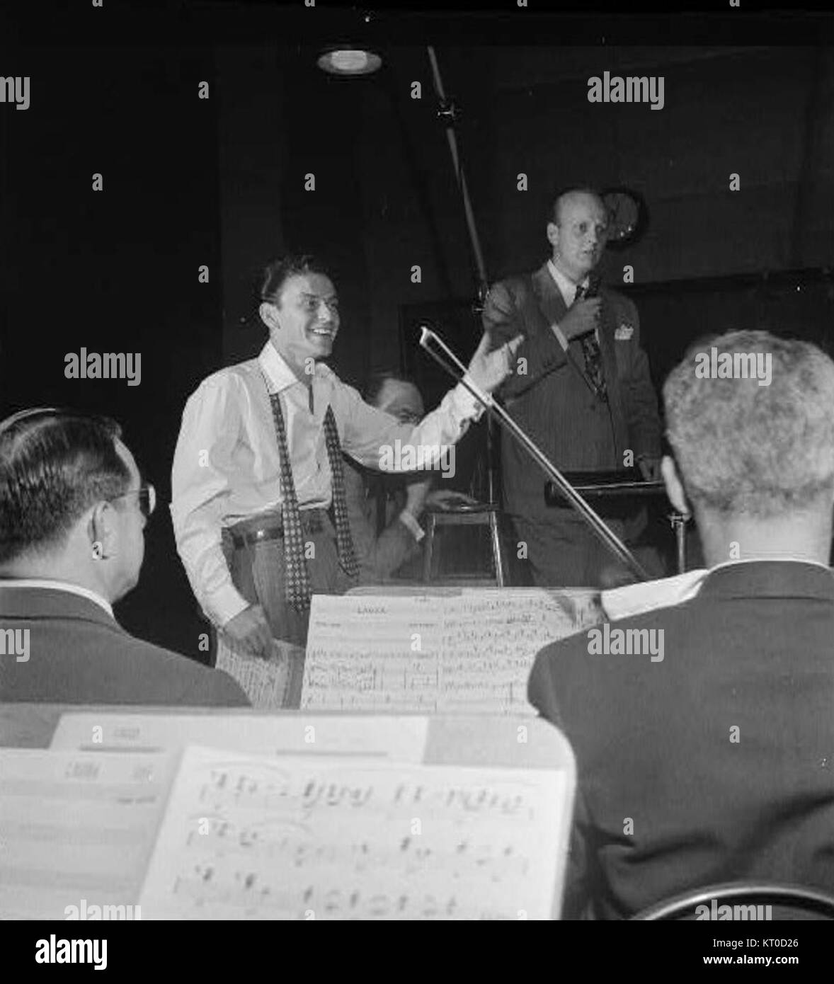 Axel Stordahl war ein renommierter Arrangeur und Dirigent, der mit Frank Sinatra zusammenarbeitete. Dieses Bild zeigt Stordahl zusammen mit Sinatra und fängt einen Moment ihrer musikalischen Partnerschaft in der Mitte des 20. Jahrhunderts ein, eine Zeit, die von ikonischen Kollaborationen in Jazz und populärer Musik geprägt ist. Stockfoto