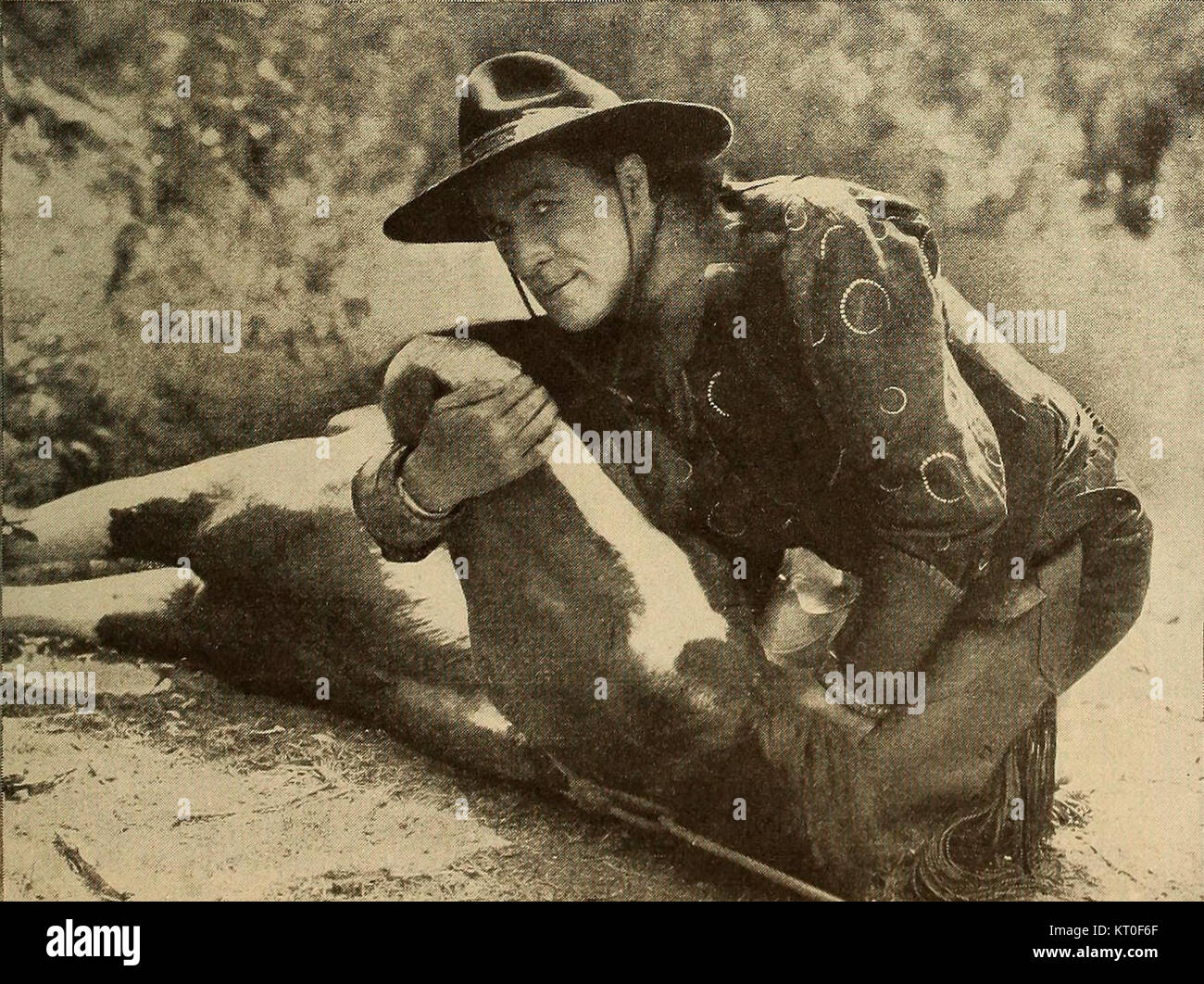 Bill Hart wird auf einem historischen Foto neben einem gefallenen Pferd festgehalten. Dieses ikonische Bild spiegelt das Leben und die Herausforderungen der frühen Cowboys im amerikanischen Westen wider und konzentriert sich dabei auf ihre Verbundenheit mit Pferden und ihren robusten Lebensstil. Stockfoto