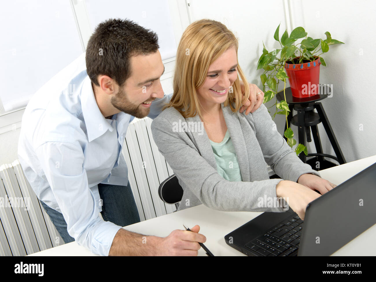 Attraktiver Mann und Frau mit Laptop Stockfoto