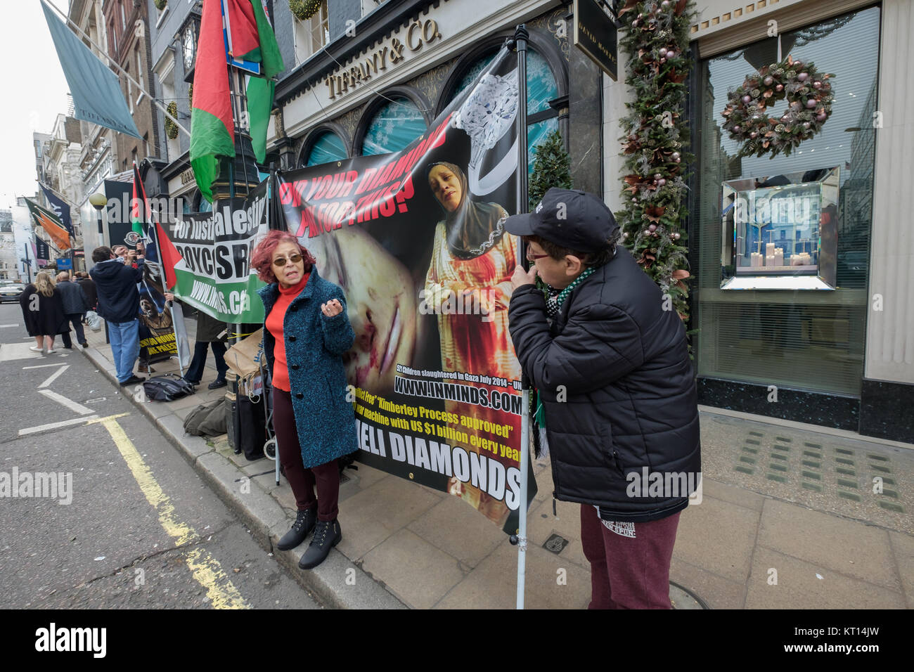 Die Demonstranten halten Banner außerhalb Tiffany gegen den Verkauf von "Blutdiamanten" aus dem Steinmetz Gruppe, die der israelischen Armee Givati Brigade, Kriegsverbrechen vorgeworfen werden, finanziert. Stockfoto