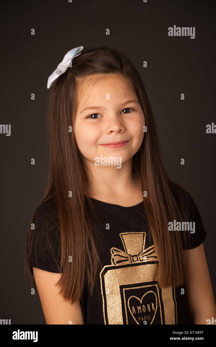 Porträt eines sieben Jahre alten Mädchen gegen einen dunklen Hintergrund stehen. Stockfoto