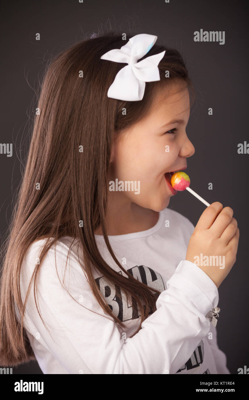 Sieben Jahre alten Mädchen mit einem Lutscher in den Mund Stockfoto