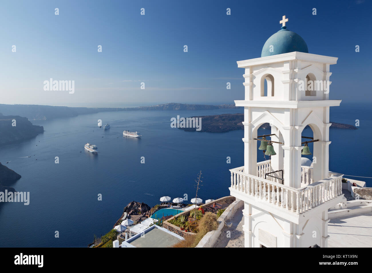 Santorini - der Turm von Anastasi Kirche in Imerovigli mit der Nea Kameni Insel im Hintergrund. Stockfoto