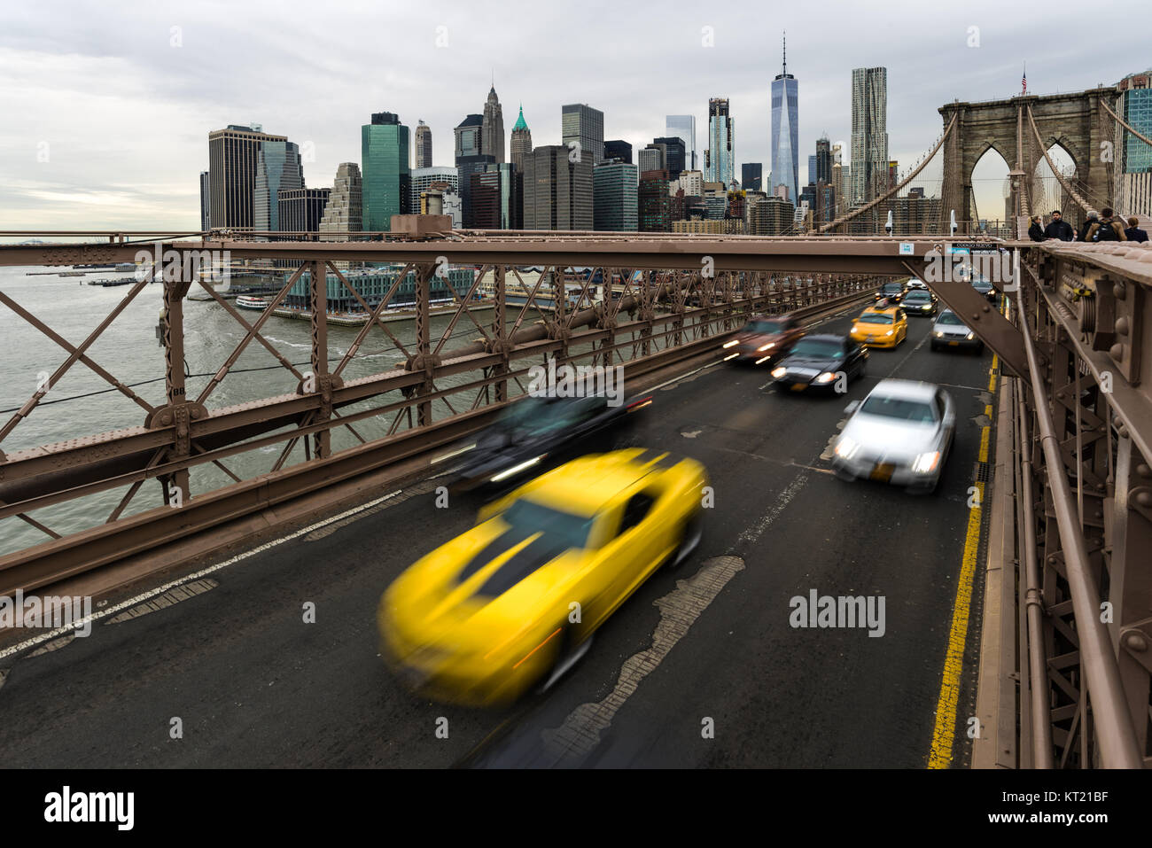 Strassenverkehr mit Fahrzeugen auf der Brooklyn Bridge und Manhattan Skyline im Hintergrund an einem bewölkten Frühling, New York, USA Stockfoto
