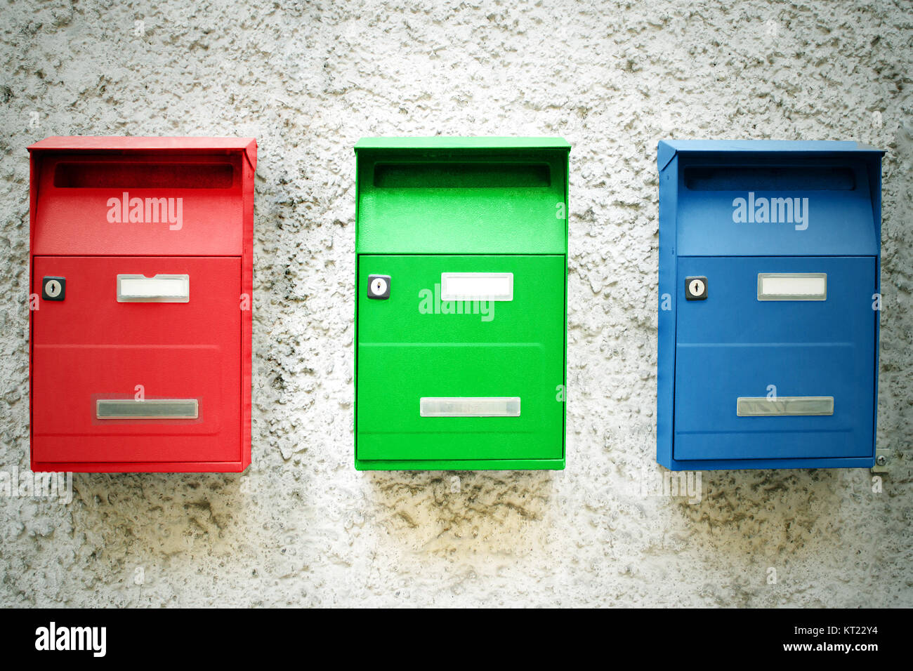 Foto von drei farbigen Mailboxen an der Wand aufhängen Stockfoto