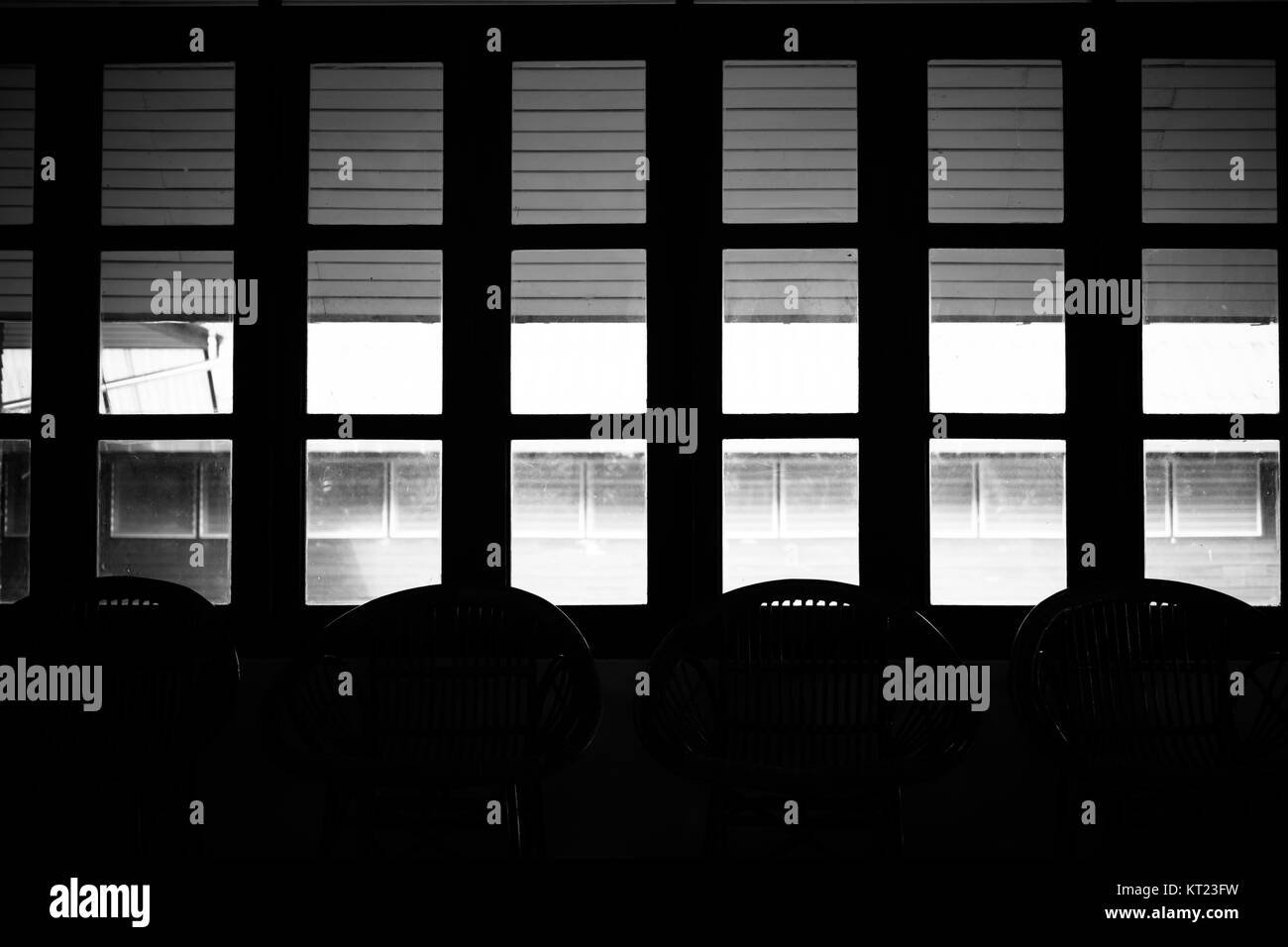 Wicker rattan Stuhl im Wohnzimmer neben Fenster, Schwarz und Weiß Stockfoto