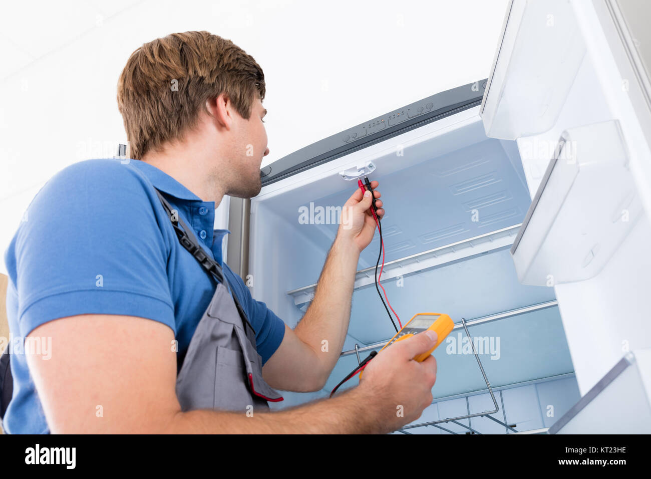 Männliche Techniker überprüfen Kühlschrank Stockfoto