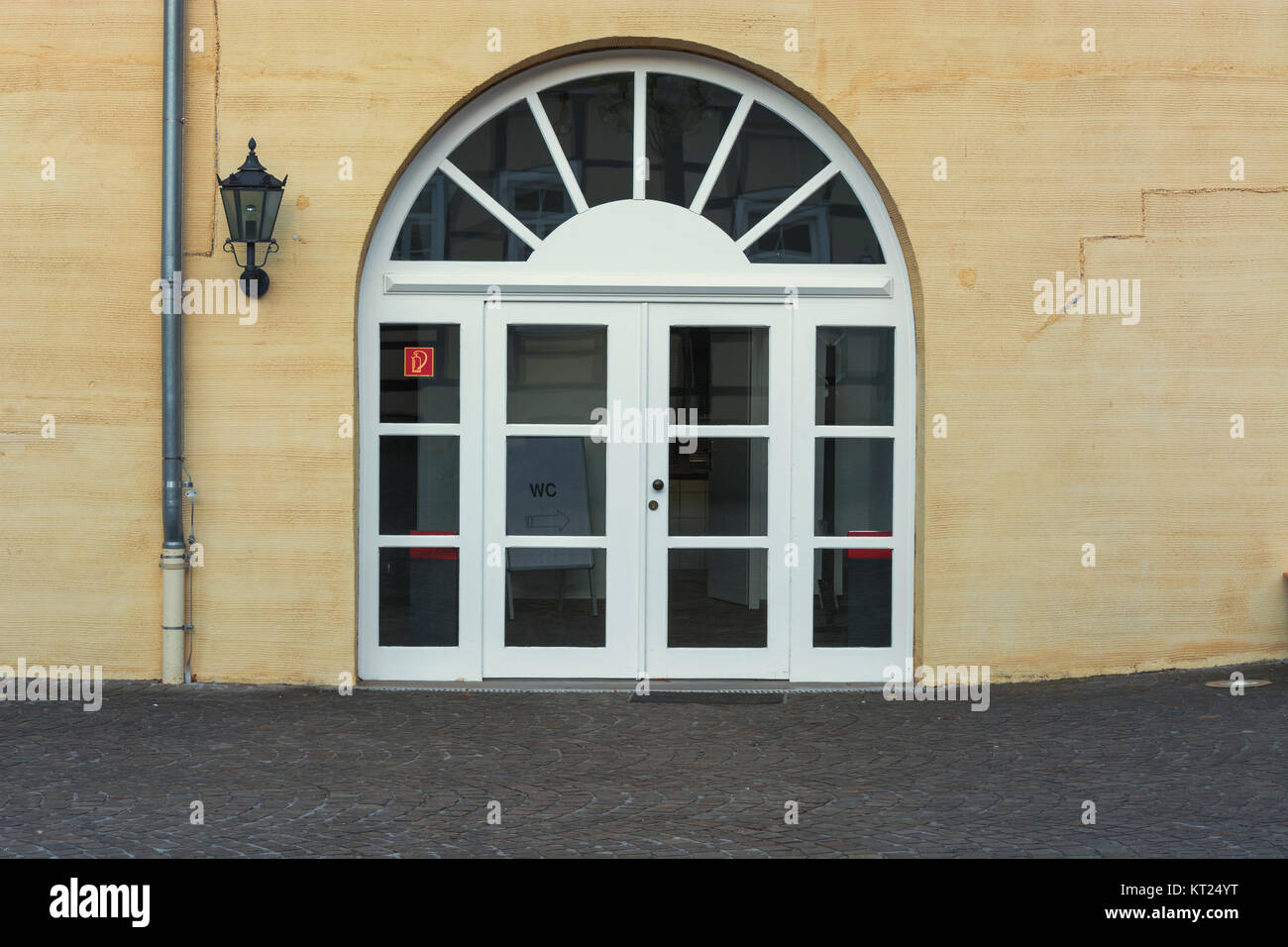 Die neue große Rundbogentür mit Sprossen in einer gelb verputzten Hauswand. Stockfoto