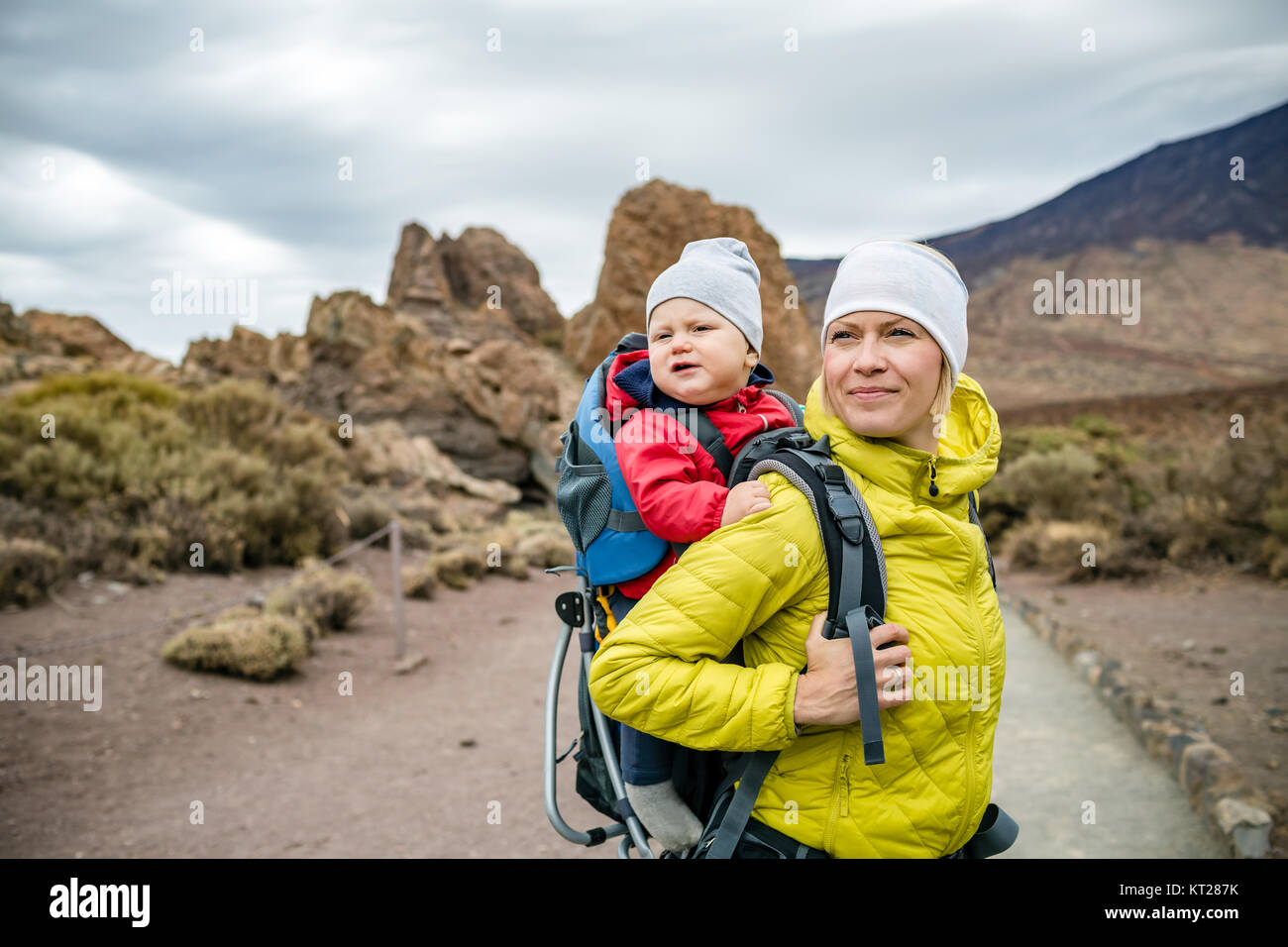 Super Mama mit Baby boy in Rucksack reisen. Mutter am Wandern Abenteuer mit Kind, Familie Urlaub in den Bergen. Urlaub Reise mit Kind durchgeführt Stockfoto