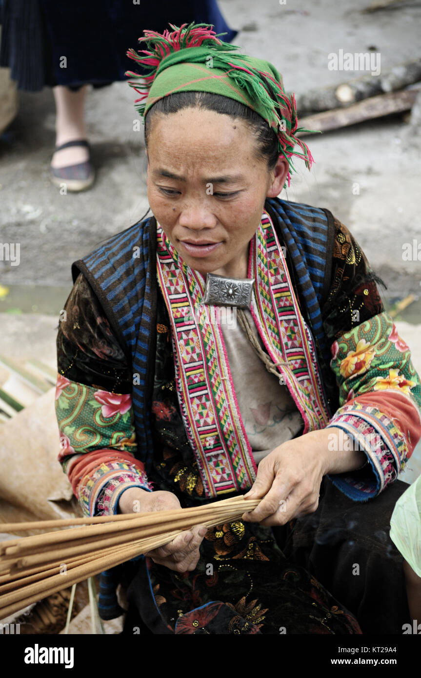Frau, die einer ethnischen Minderheit mit traditionellen Kleid bei Meo Vac Markt sitzend, Provinz Ha Giang, Vietnam Stockfoto