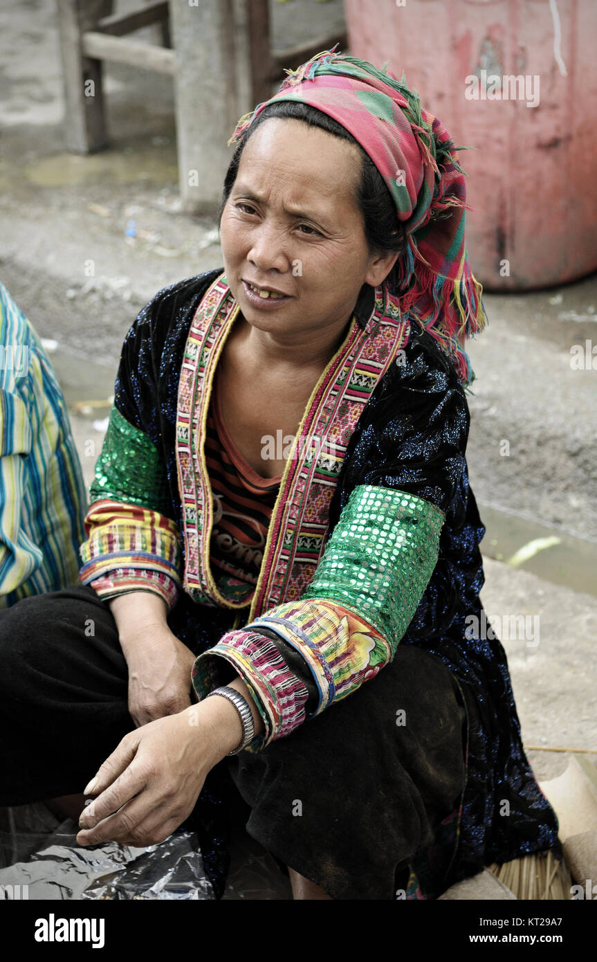 Tribeswoman mit traditionellen Kleid bei Meo Vac Markt sitzend, Provinz Ha Giang, Vietnam Stockfoto