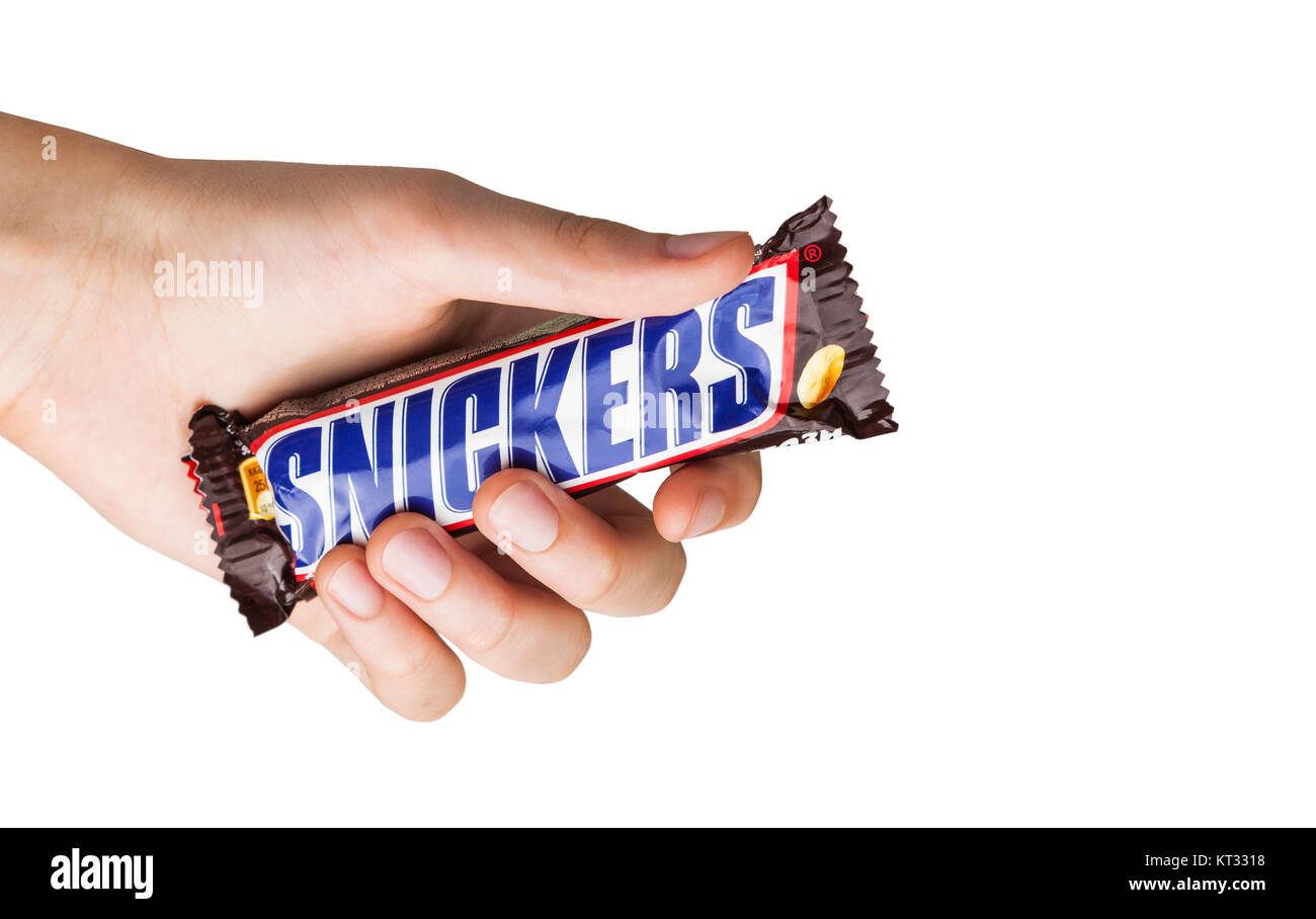 CHISINAU, Moldawien - Dezember 21, 2017: Hand mit einem Snickers Schokoriegel. Snickers bars sind produziert von Mars, Incorporated. Snickers wurde erstellt von Stockfoto