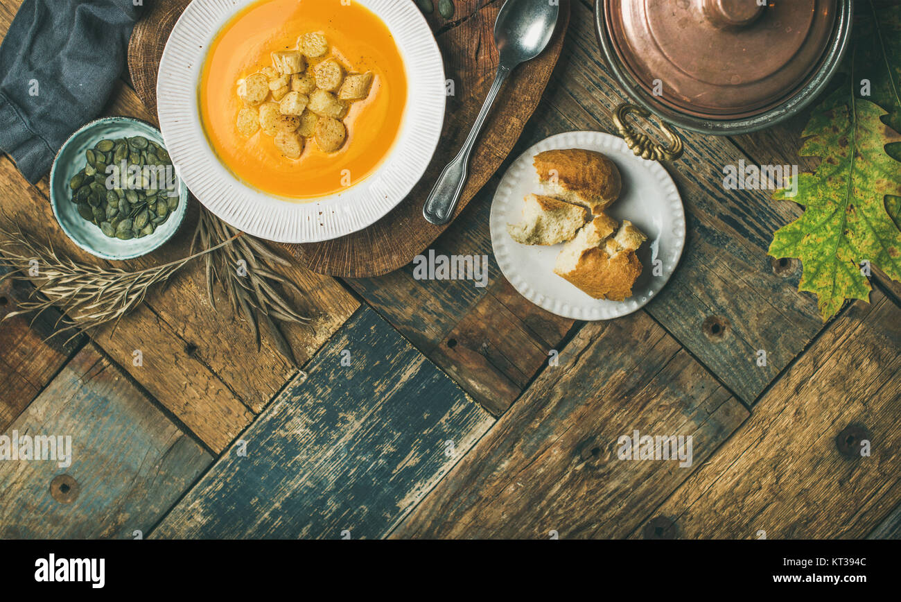 Herbst Erwärmung Kürbis creme Suppe mit Croutons und Samen an Bord über rustikal Hintergrund, Kopieren, Flachbild-Lay, Ansicht von oben. Herbst vegetarisch, Veg Stockfoto