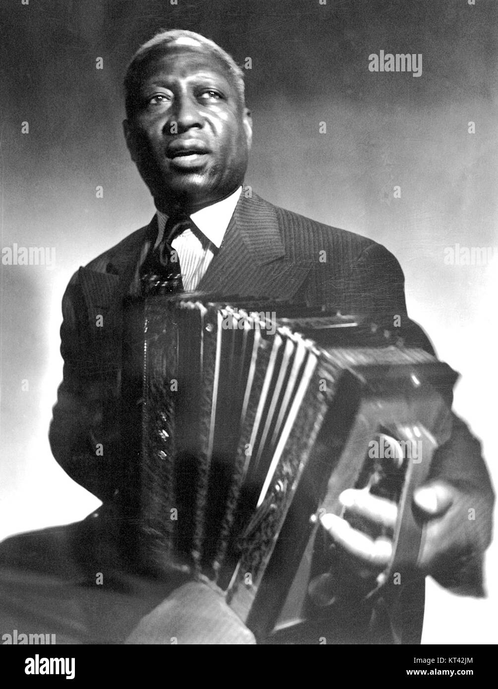 Leadbelly, ein legendärer amerikanischer Folk- und Bluesmusiker, ist hier mit einem Akkordeon zu sehen. Leadbelly war bekannt für seinen Einfluss auf die amerikanische Musik und zeigte seine Beherrschung mehrerer Instrumente, einschließlich des Akkordeons, das für seinen Volksmusikstil von zentraler Bedeutung war. Stockfoto