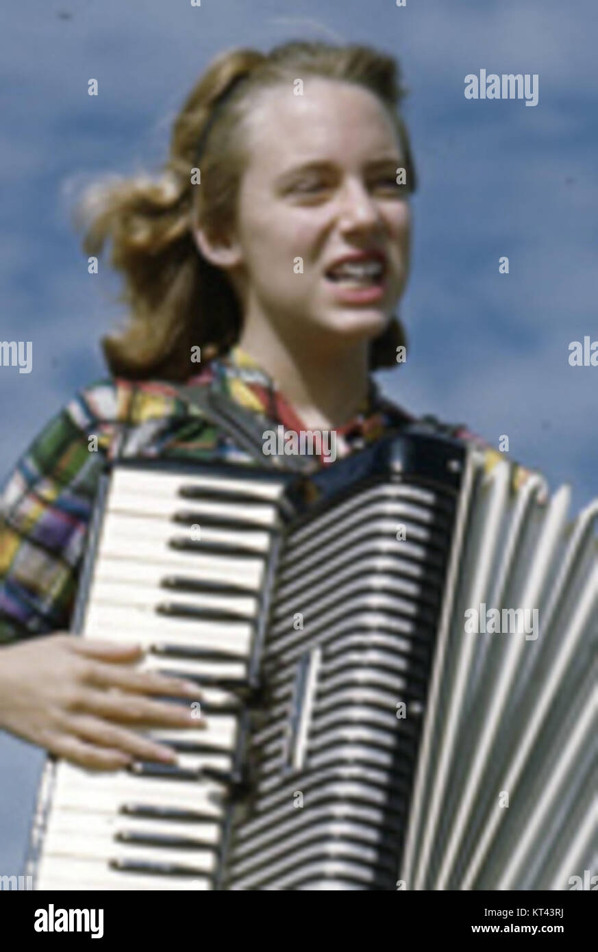 Lois Duncan Steinmetz spielt Akkordeon an Bord des Shantyboat Lazy Bones, aufgenommen in einem Vintage-Foto, das Musik und Freizeit auf einem historischen Boot zeigt. Stockfoto