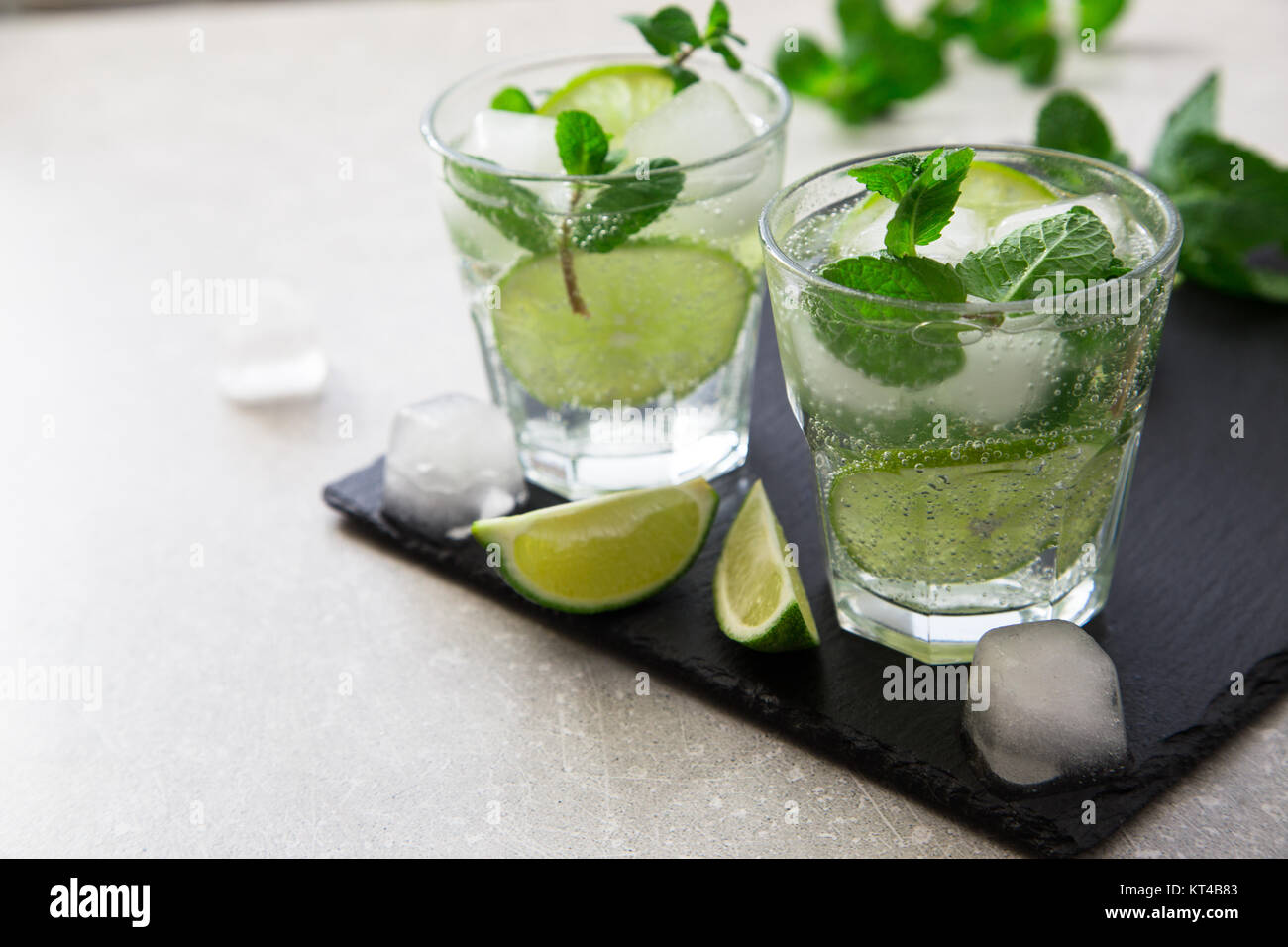 Kalte Limonade Erfrischende Sommer Mojito in einem Glas auf einer Schiefertafel Brett und Stein. Stockfoto