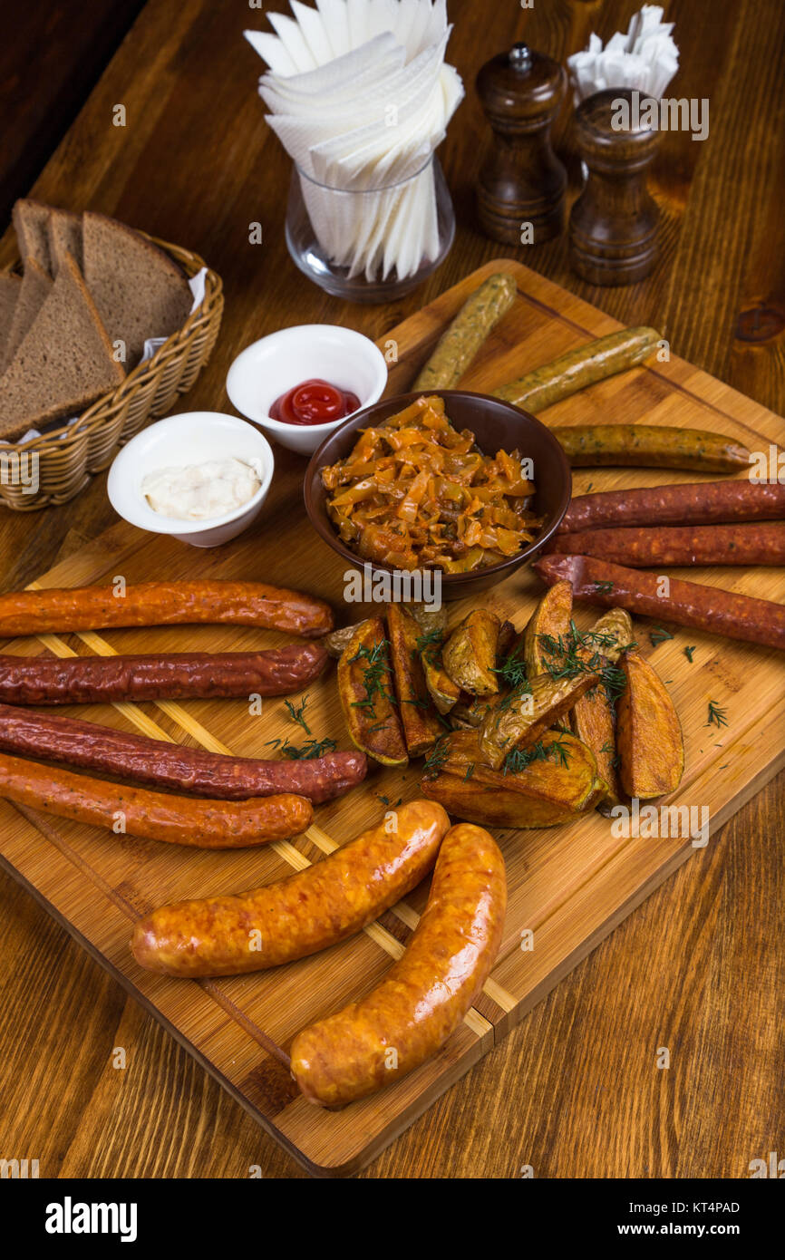 Sortiment heiße Würstchen serviert auf Holzbrett Stockfoto