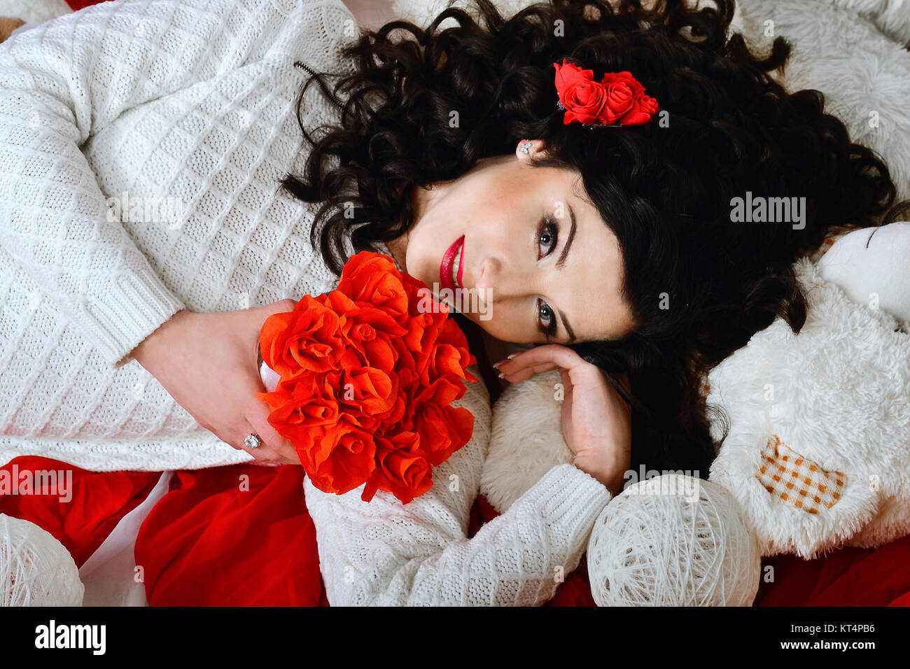 Sehr schön, nett, kreativ, schön, attraktiv, Wunderbar, Wunderbar, Wunderbar, modisch, glamourösen brunette Mädchen mit dunklen, lockiges Haar und Schönen Blumenstrauß aus roten Rosen. Urlaub St. Valentinstag. Stockfoto