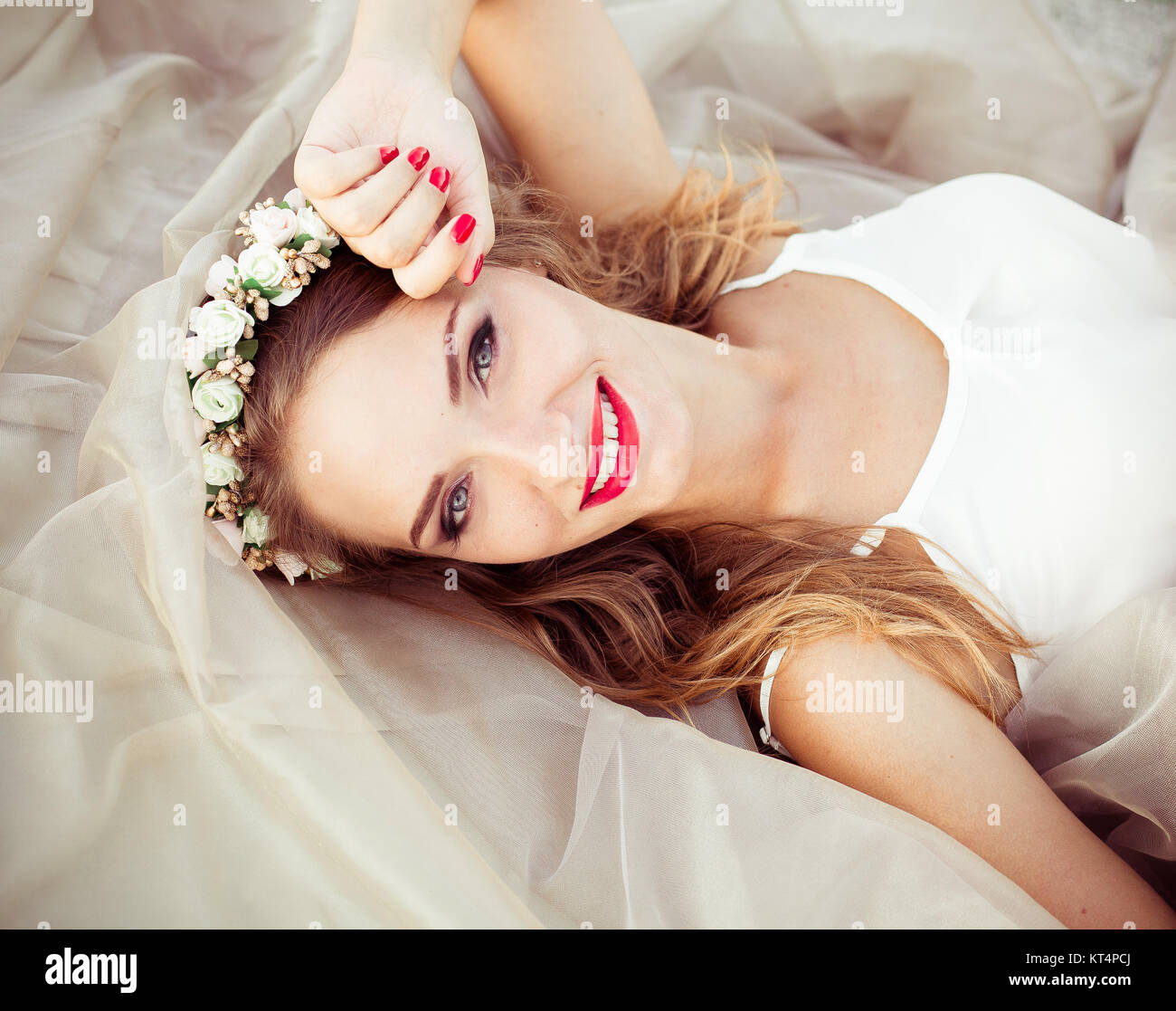 Porträt einer schöne Mode Braut, süß und sinnlich. Hochzeit Make-up und Haare. Blumen Hintergrund. Im modernen Stil. Blaue Augen. Bild von Happy fröhlich lächelnde Mädchen mit großen weißen gesundes Lächeln Stockfoto