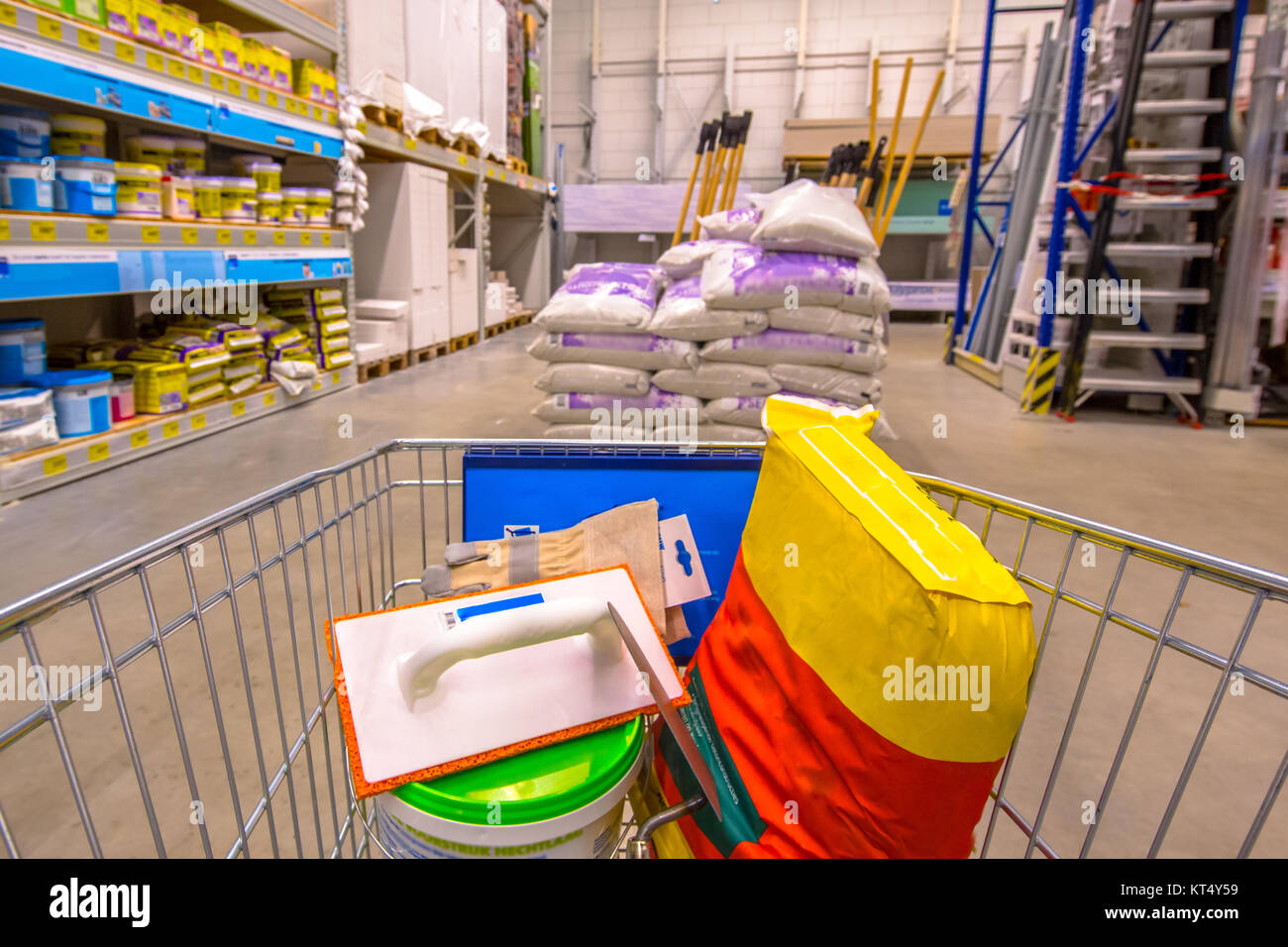 Warenkorb im Baumarkt Baumarkt mit Sandisk Zement, Werkzeuge und andere Güter Beton Boden legen Stockfoto