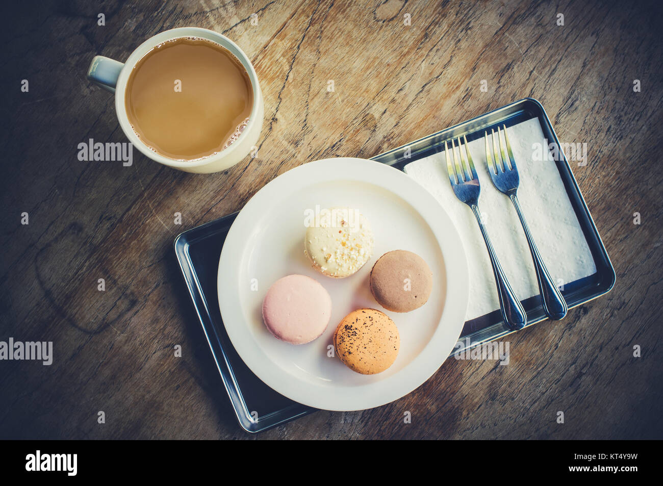 Tasse Kaffee mit Macarons auf hölzernen Tisch gesetzt. Stockfoto