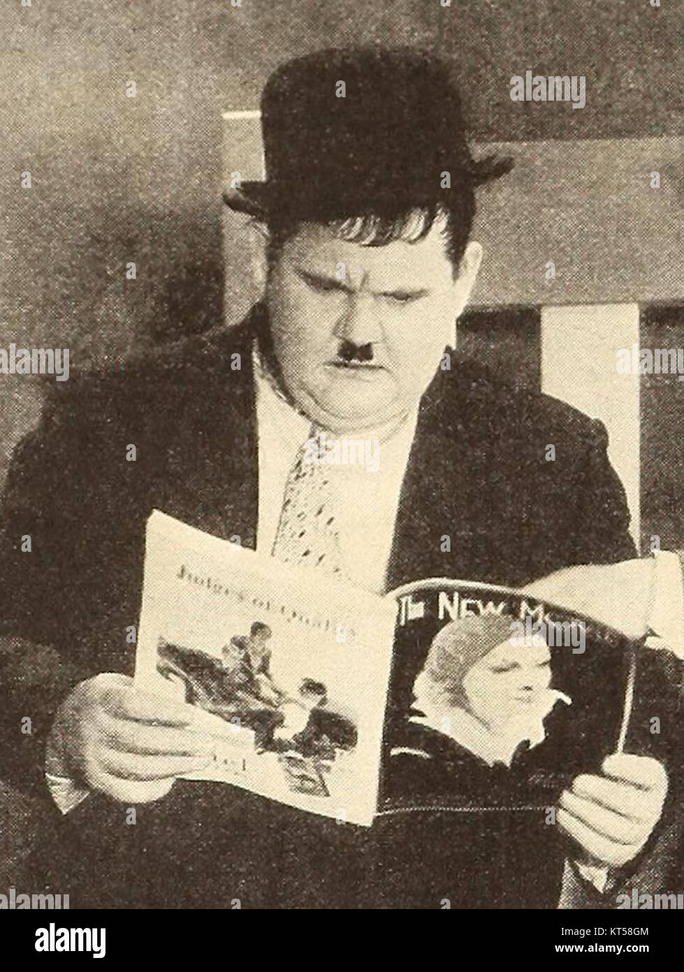 Das Bild zeigt Oliver Hardy, einen legendären Komiker, der „The New Movie“ liest. Oliver Hardy ist vor allem für seine Auftritte im klassischen Comedy-Duo Laurel and Hardy bekannt, das im Kino des frühen 20. Jahrhunderts zu einem Wahrzeichen wurde. Stockfoto