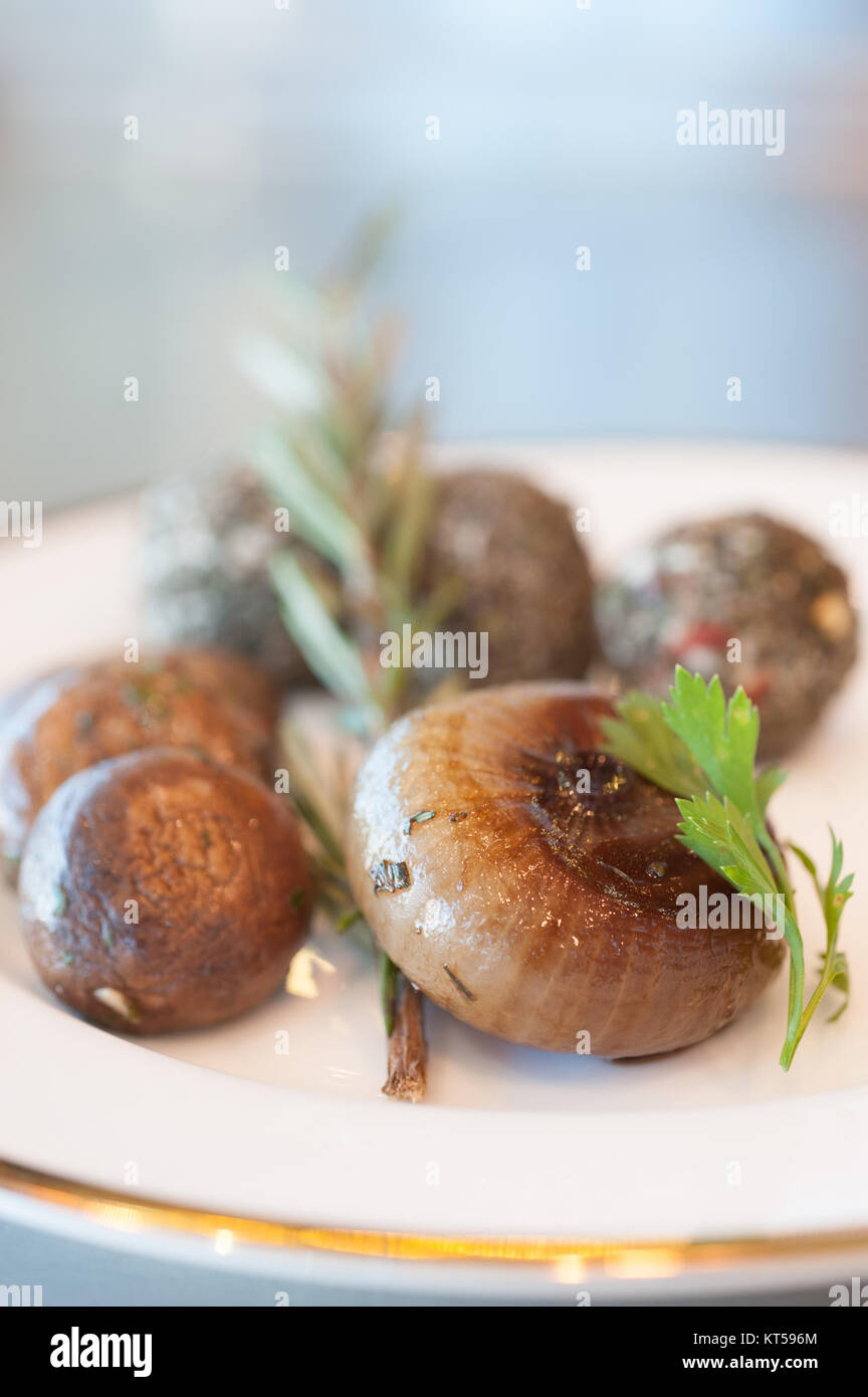 Pilze und Zwiebeln auf einem Teller mit Kräuter Stockfoto