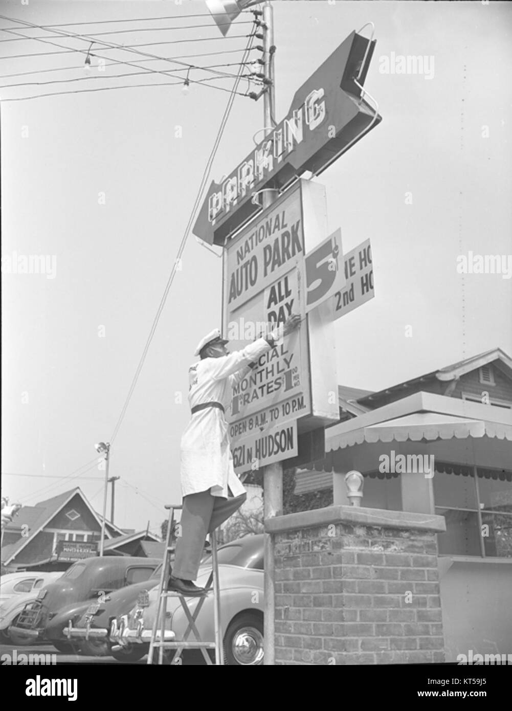 Dieses Bild von einem Parkplatz aus dem Jahr 1949 zeigt Autos, die in einer typischen Umgebung aus der Mitte des 20. Jahrhunderts geparkt sind. Die Parkgebühr von 5 Cent spiegelt die damaligen wirtschaftlichen Bedingungen wider, in denen Parken ein erschwinglicher Service für Fahrer war. Stockfoto