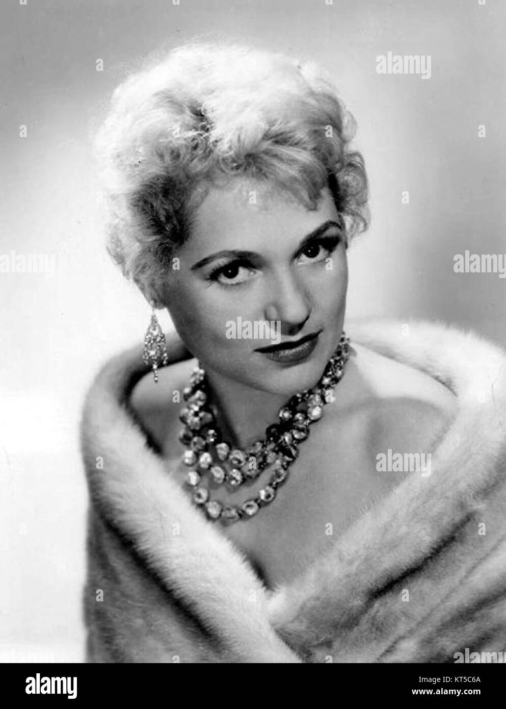 Dieses Werbefoto zeigt Judy Holliday, eine US-amerikanische Schauspielerin, die vor allem für ihre komödiantischen Rollen in Filmen wie *Born Yesterday* bekannt ist. Das Bild spiegelt die Ära des Goldenen Zeitalters Hollywoods wider. Stockfoto