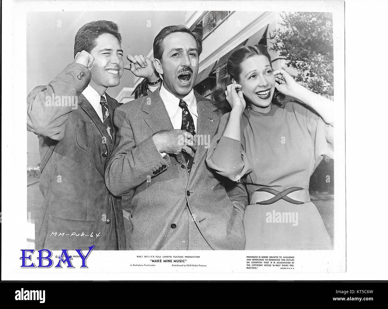 Dieses Werbefoto aus dem Film *Make Mine Music* aus dem Jahr 1946 zeigt Andy Russell, Walt Disney und Dinah Shore. Der Film, ein Disney-animiertes Musical, ist bekannt für seine Mischung aus animierten Segmenten und Musik und zeigte prominente Persönlichkeiten aus der Musik- und Filmindustrie. Stockfoto