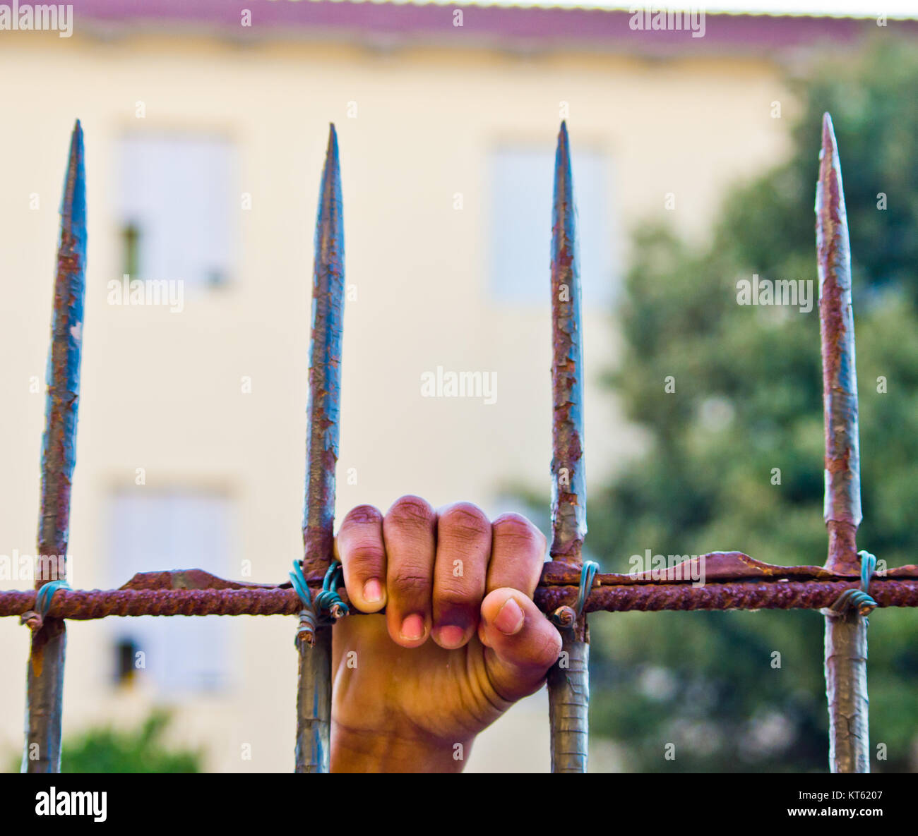 Hand von verurteilten Mann packt die Bars mit Spitzen des Gefängnisses. Stockfoto