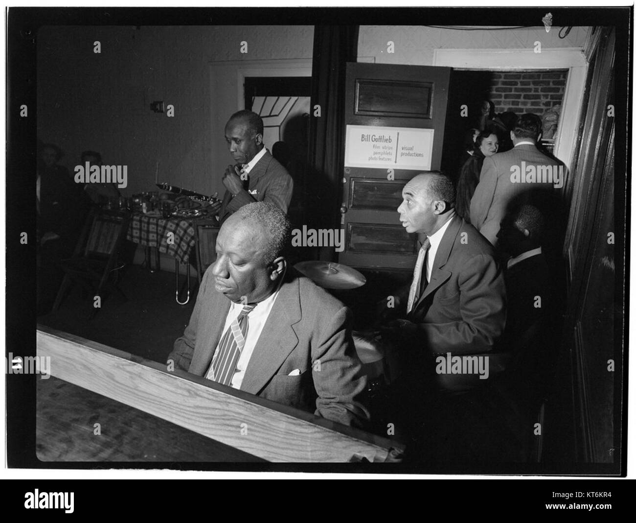Dieses Foto aus der Zeit um 1948 zeigt prominente Jazzmusiker James P. Johnson, Fess Williams, Freddie Moore und Joe Thomas bei einer Party des Fotografen William P. Gottlieb in Jamaica, Queens, New York. Das Bild fängt einen Moment der gesellschaftlichen Begegnung unter namhaften Persönlichkeiten der Jazzgeschichte ein. Stockfoto