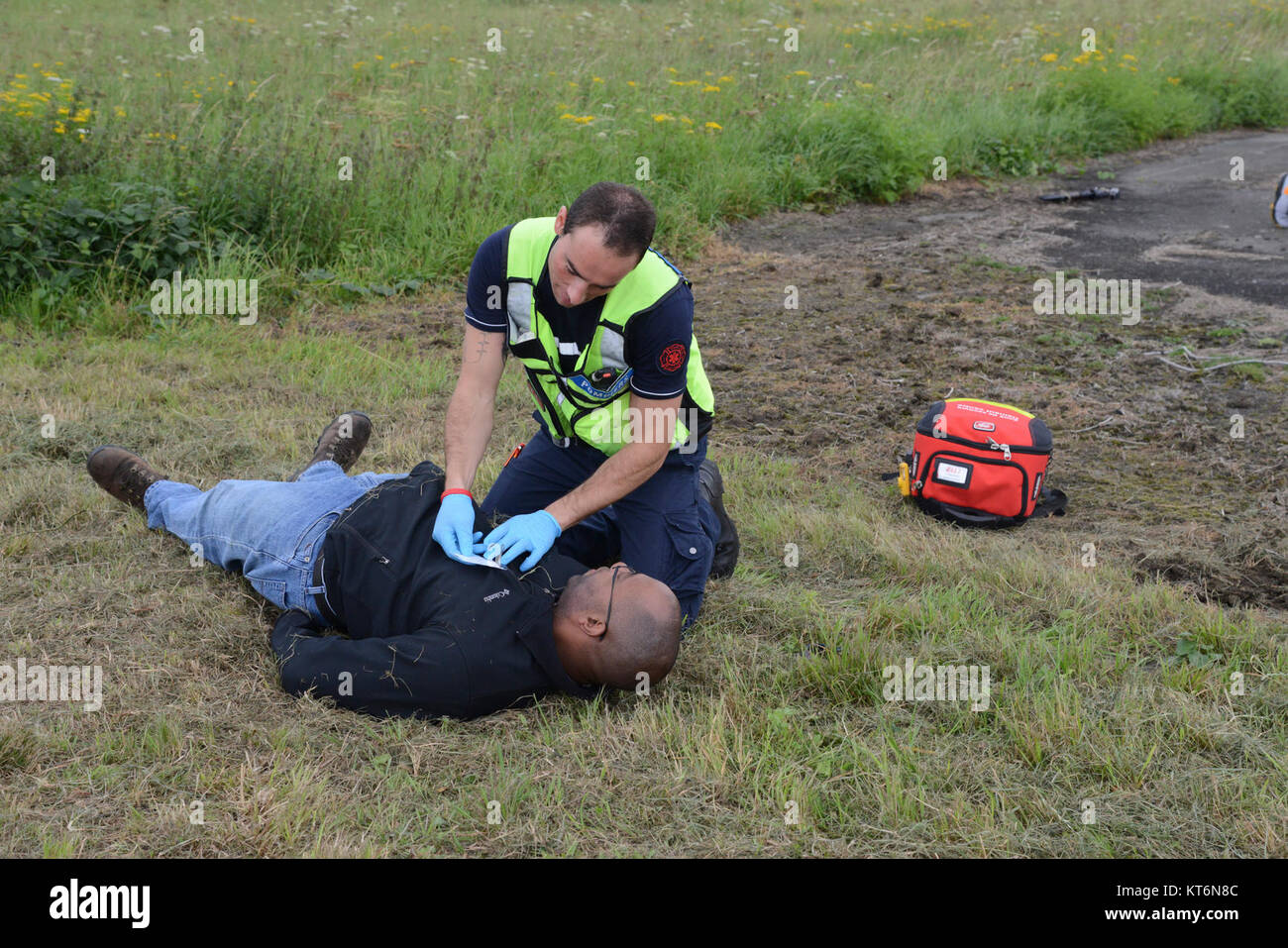 Ein Mitglied der belgischen Emergency Medical Services für medizinische Versorgung zu einer Rolle Spieler während Sentinel Schild 2017, eine großangelegte Übung der Beurteilung der Zusammenarbeit zwischen US-Armee Garnison Benelux, Mieter und belgischen zivilen Behörden in Krisensituationen, auf chièvres Air Base, Belgien, Sept. 7, 2017. (U.S. Armee Stockfoto