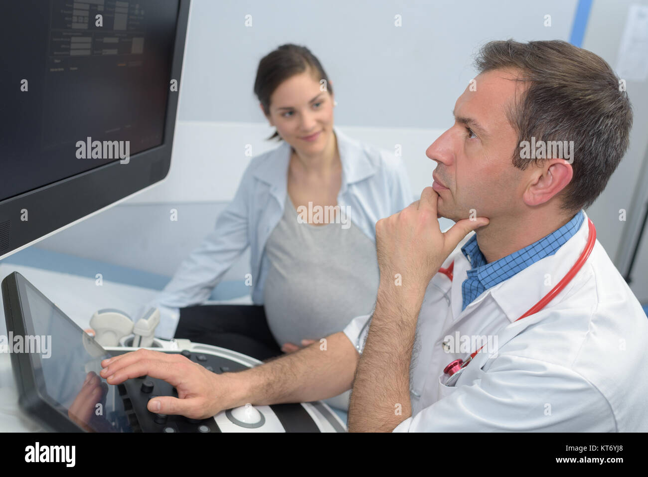Schwangere Frau und Arzt prüfen der Ultraschall Stockfoto