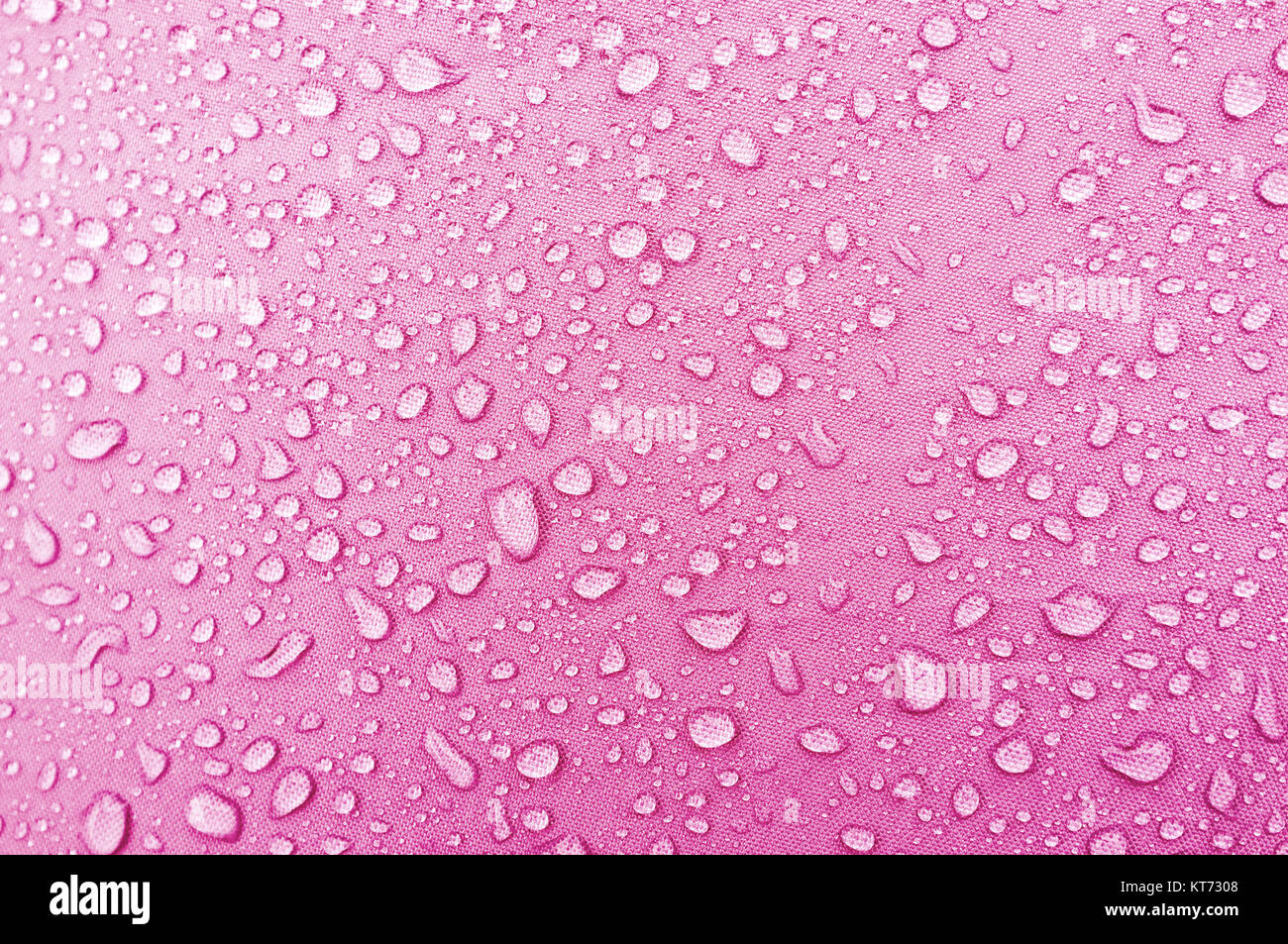 Wassertropfen auf rosa Fibre wasserdichtes Gewebe. Stockfoto