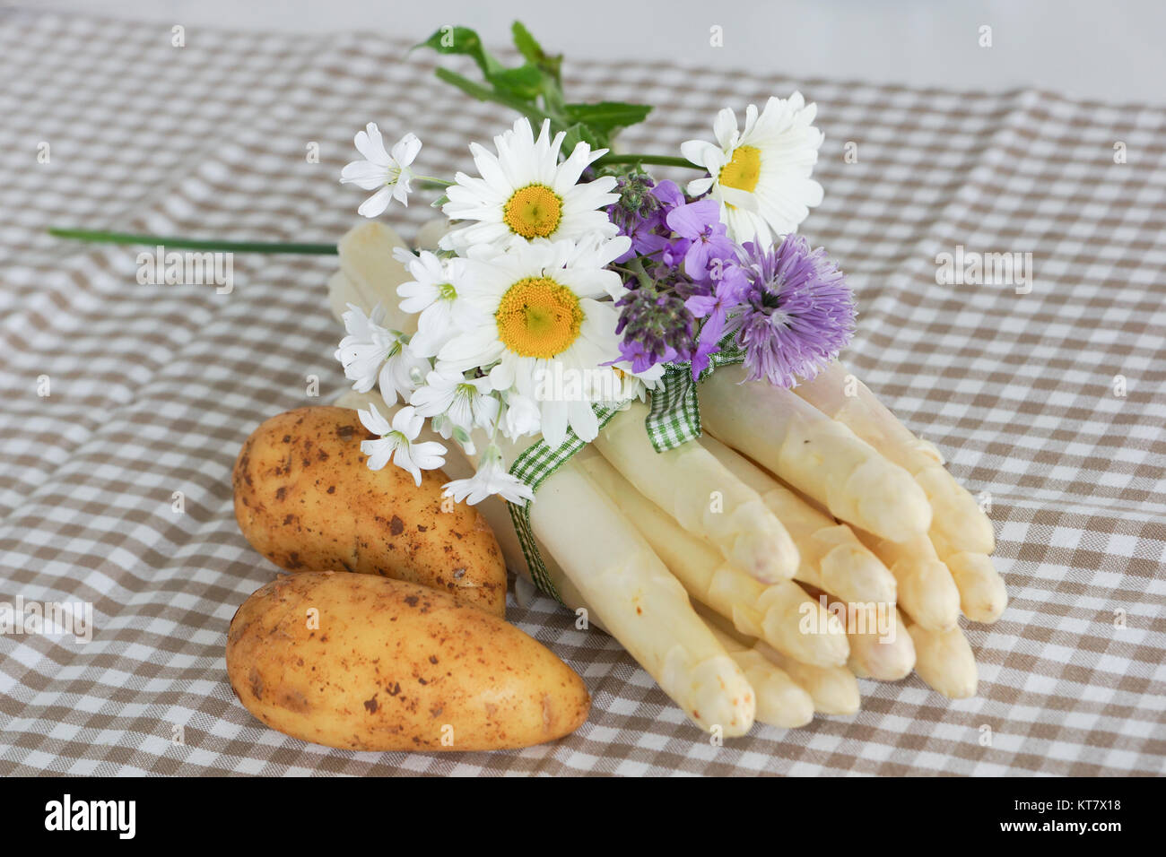 Spargel schön mit Schnittlauch, Blumen und Band mit Süßkartoffeln verziert Stockfoto