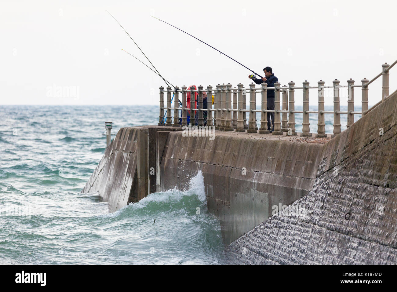 Männer angeln vom Hafen Arm der Altstadt von Hastings Stockfoto