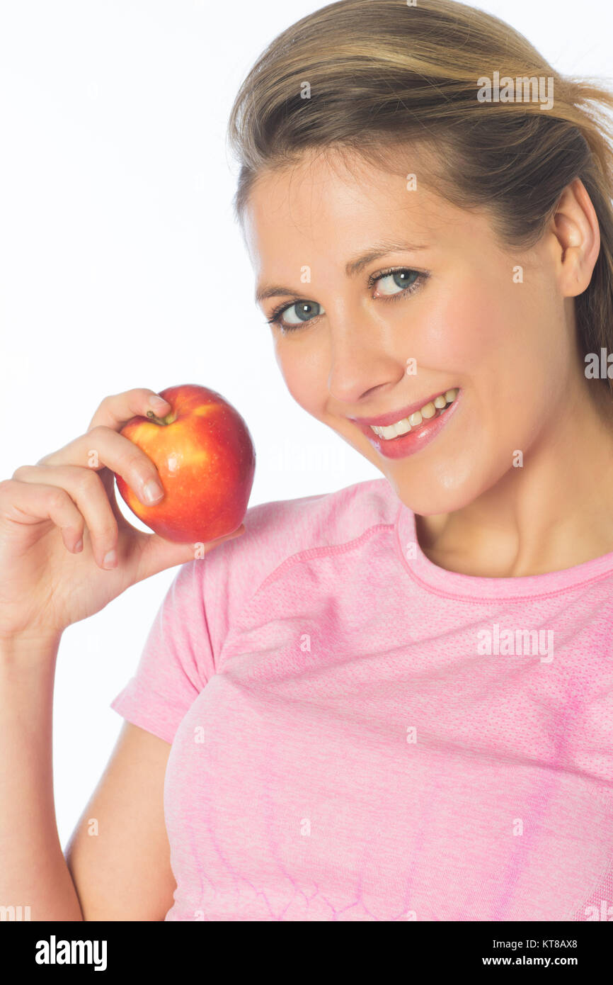 Schöne blonde Frau mit einem roten Apfel vor einem weißen Hintergrund Stockfoto