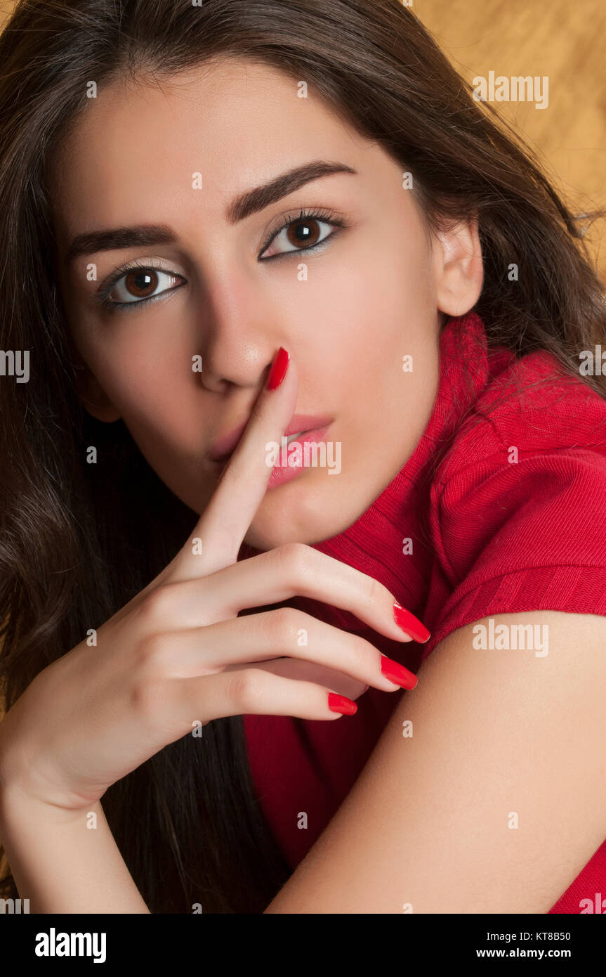 Schöne junge Frau finger berühren Lippen in Stille Geste Stockfoto