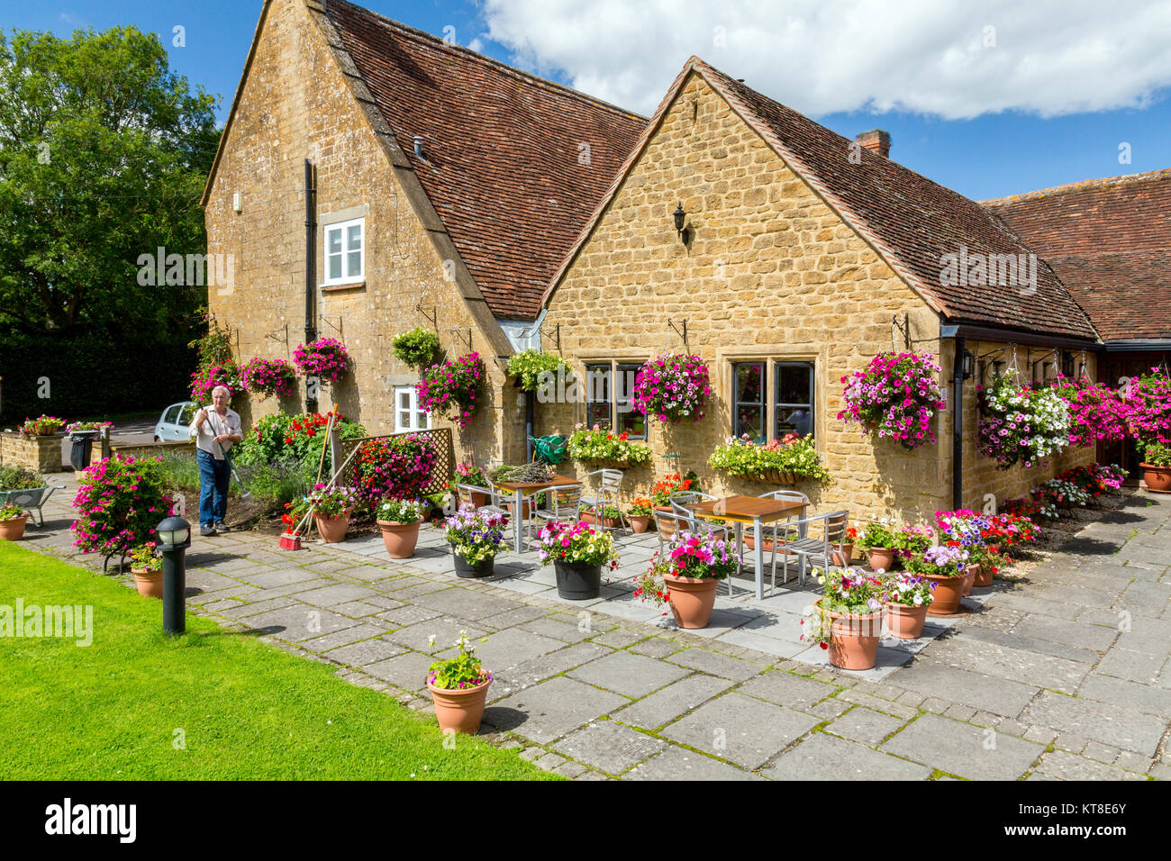 Die prächtigen und farbenfrohen Blumen hängende Körbe und Wannen außerhalb der Rose und Crown Inn at East Lambrook, Somerset, England, Großbritannien Stockfoto